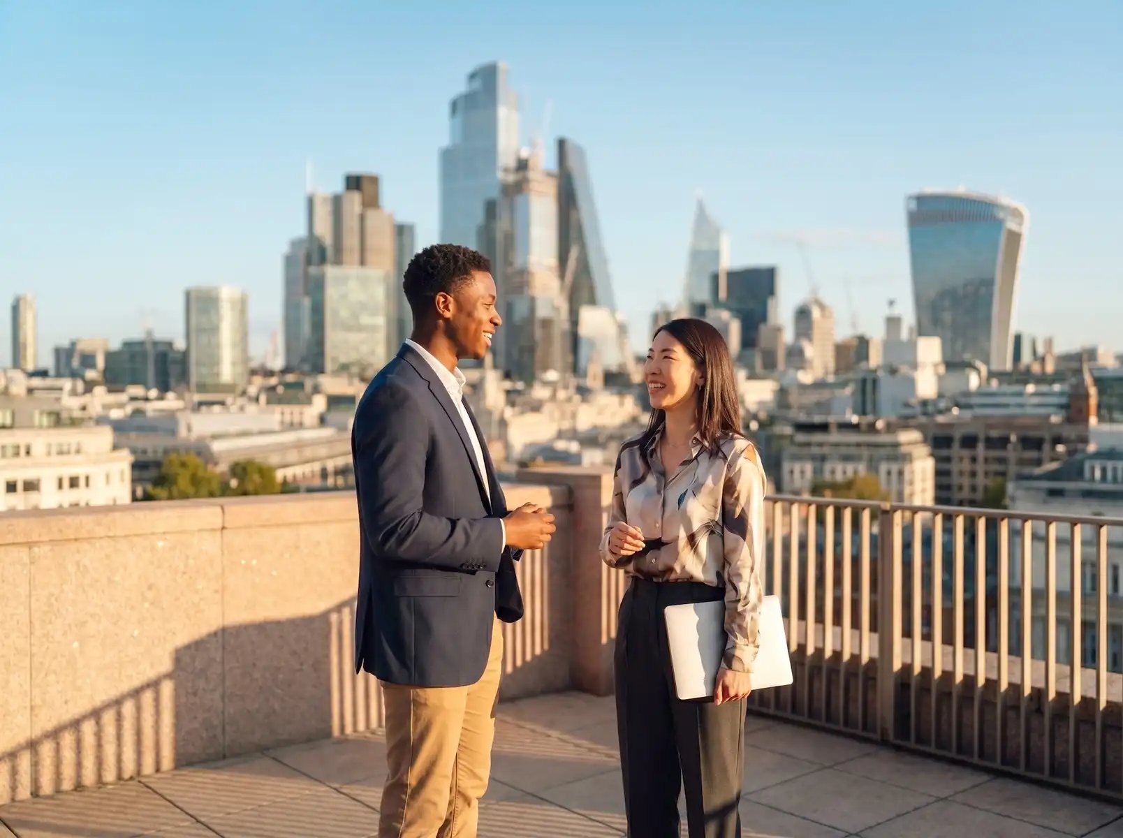 Two business professionals networking on a rooftop with a city skyline in the background.