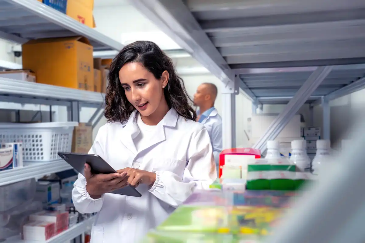 woman pharmacist in the deposit with tablet in hand