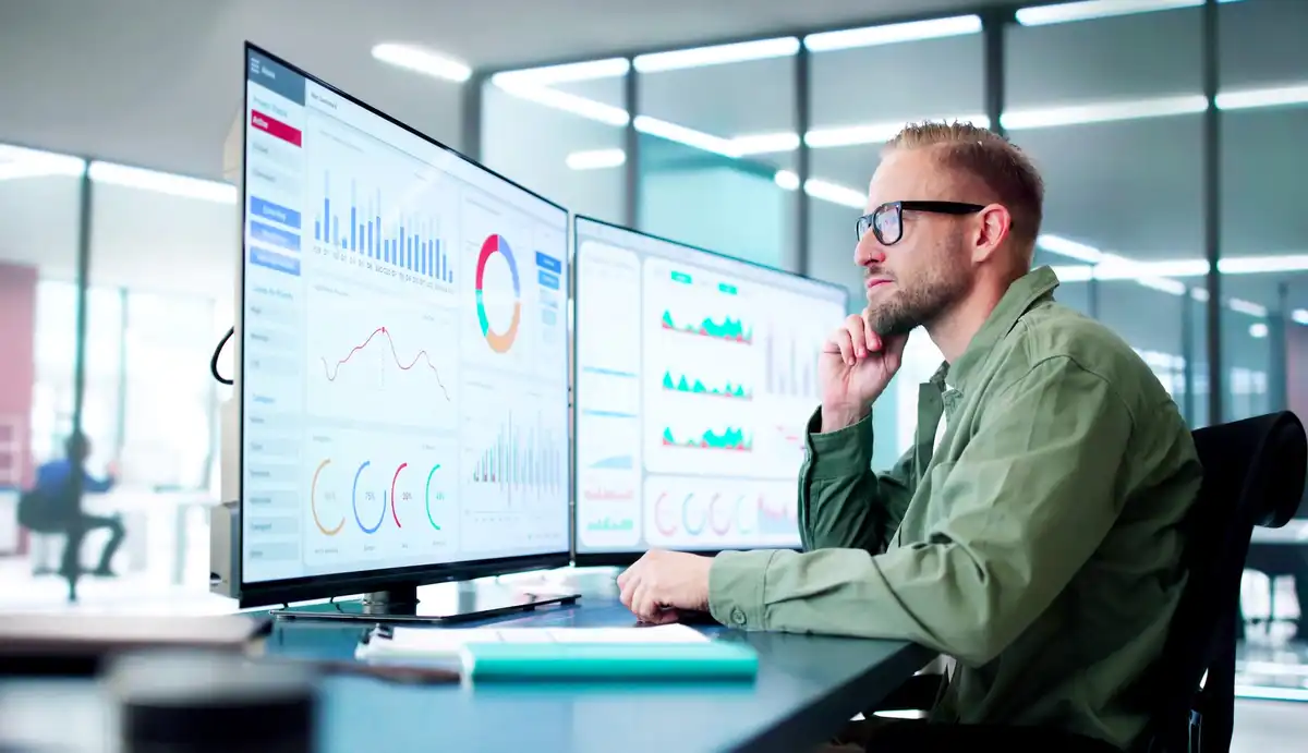 man in front ofthe monitor analyzing data